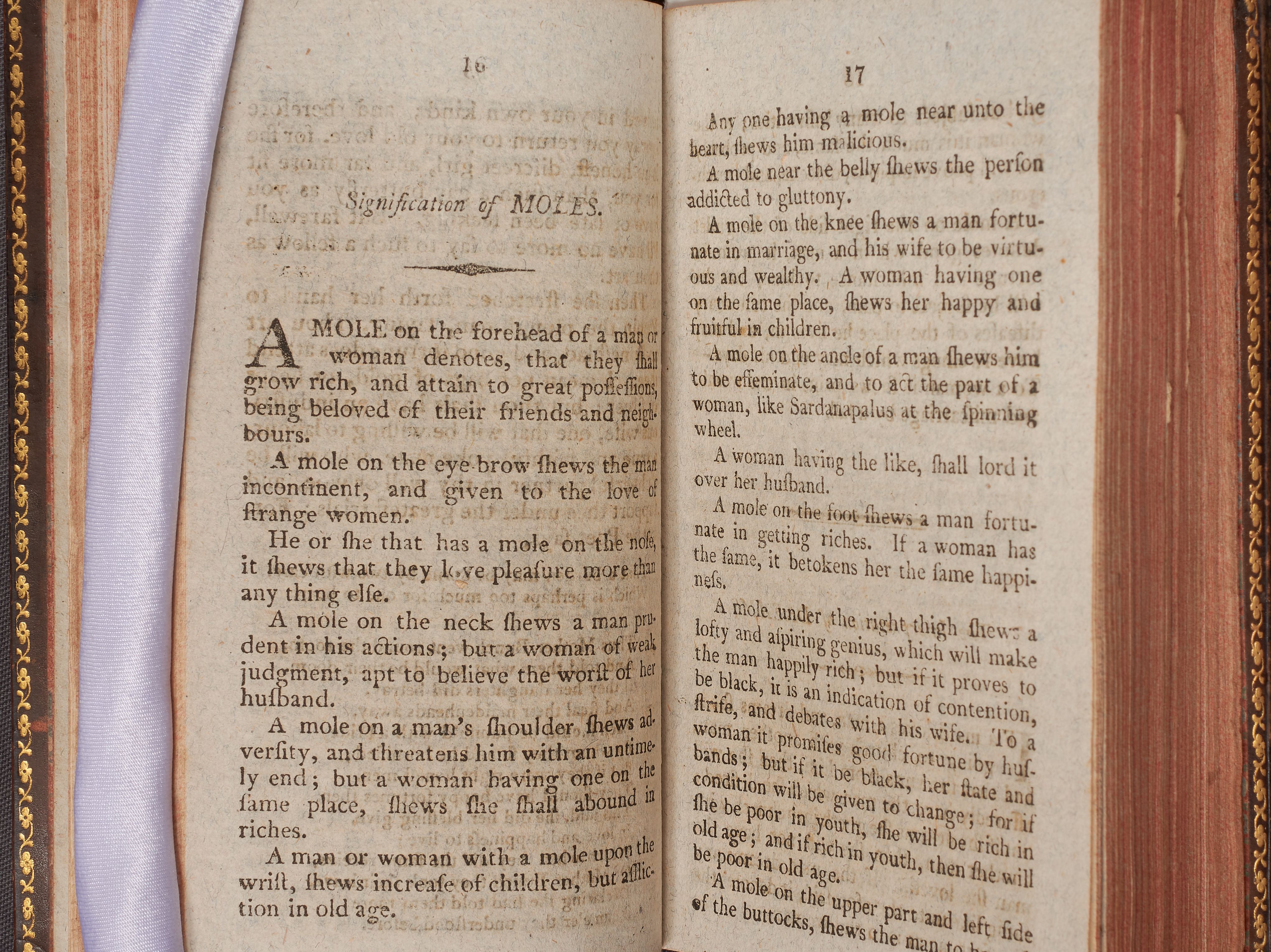 A double page from a printed book with instructions on how to use moles to predict a person’s future.