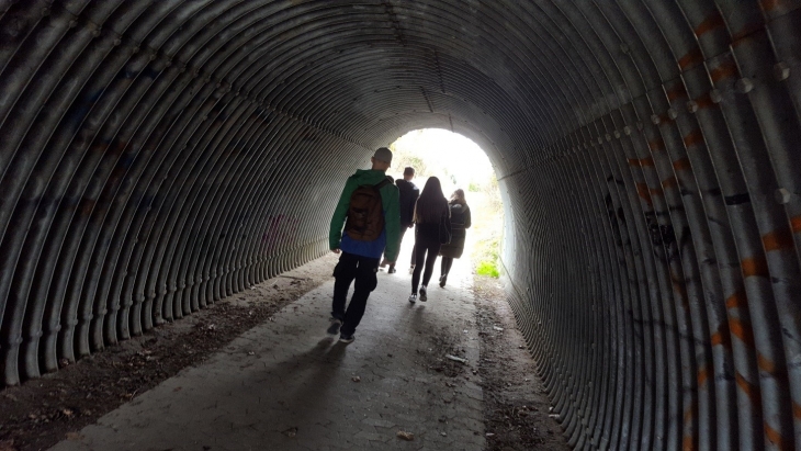 image of young people walking through a tunnel